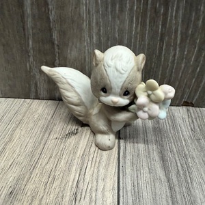 PRECIOUS MOMENTS SKUNK HOLDING FLOWERS